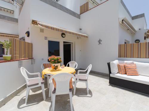 a patio with a table and chairs and a couch at Granada II Apartments in Puerto Rico de Gran Canaria