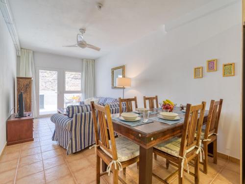 a dining room and living room with a table and chairs at Granada II Apartments in Puerto Rico de Gran Canaria