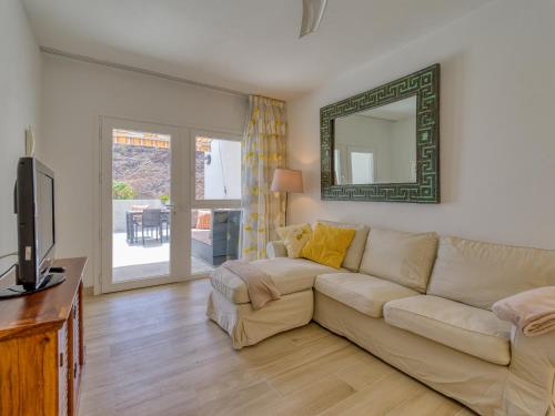 a living room with a couch and a mirror at Granada II Apartments in Puerto Rico de Gran Canaria