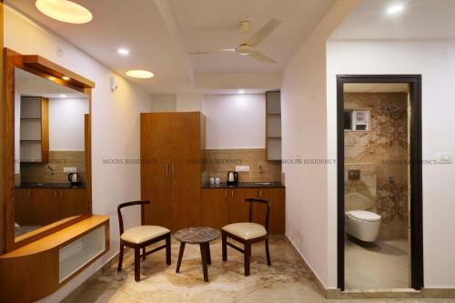 a bathroom with two chairs and a table and a toilet at Moois Residency ,Bangalore in Bangalore