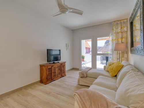 a living room with a couch and a tv at Granada II Apartments in Puerto Rico de Gran Canaria