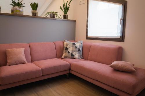 a pink couch in a living room with a window at La Casa Di Filò Boutique in Roseto degli Abruzzi