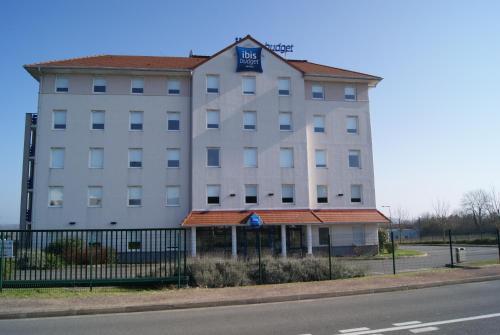 a large white building on the side of the road at ibis budget Nevers Varennes Vauzelles in Varennes Vauzelles