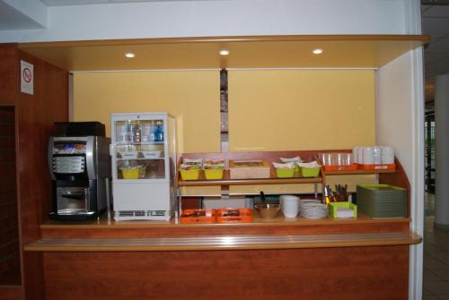 a kitchen with a counter with a microwave and a refrigerator at ibis budget Nevers Varennes Vauzelles in Varennes Vauzelles