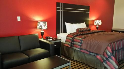 Habitación de hotel con cama y sofá en Texan Inn and Suites Tilden, en Tilden