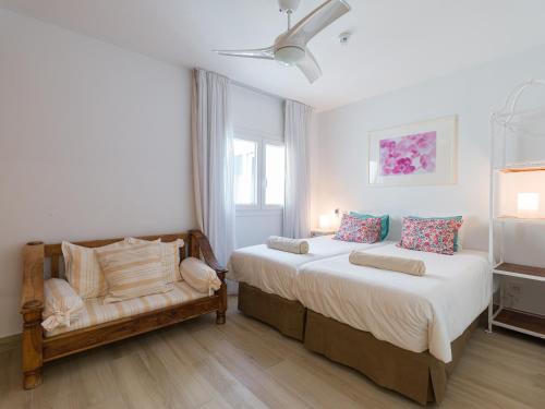 a bedroom with a large bed and a chair at Granada II Apartments in Puerto Rico de Gran Canaria