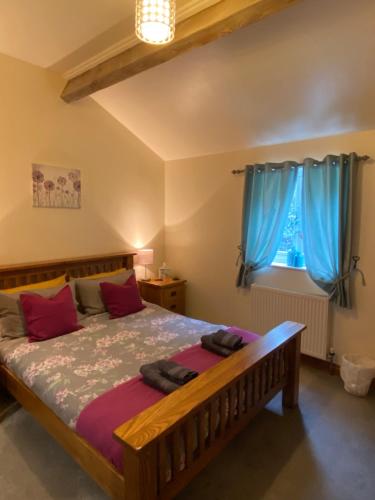 a bedroom with a large bed with blue curtains at Mowbray Stable Cottages in Thirsk