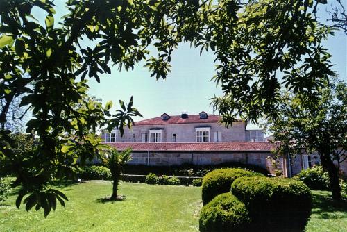 a large building in the middle of a yard at Pazo Almuzara in Boborás