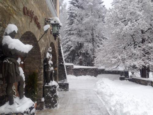 a street light covered in snow next to a building at Complex La Tunuri - Vila Economat in Sinaia