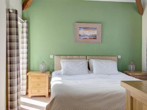 a bedroom with a bed and a picture on the wall at Priory Barn in Frocester