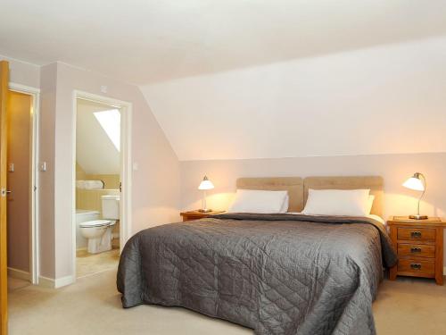 a bedroom with a large bed and a bathroom at Hay Fields, Tilmangate Farm in Ulcombe