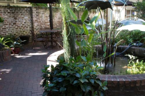 a garden with a fountain with plants and a table at Eliza Thompson House, Historic Inns of Savannah Collection in Savannah