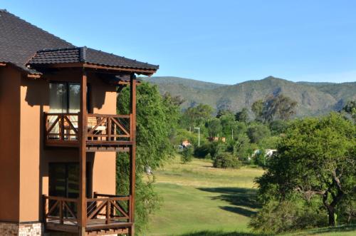 a building with a gazebo next to a field at Ayres del Champaqui Hotel Boutique Experiencial & Spa in Villa General Belgrano