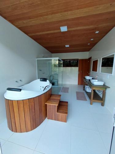 a large bathroom with a tub and a sink at Lumiar Eco Lodge - Chalé Pedra Riscada in Nova Friburgo