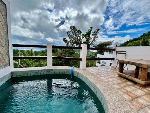 a pool on a patio with a table and a bench at KohTao Studios Sunset in Koh Tao