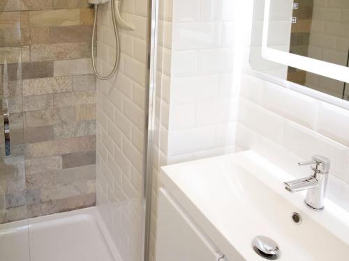 biała łazienka z umywalką i prysznicem w obiekcie The White House Studio w mieście Worthing