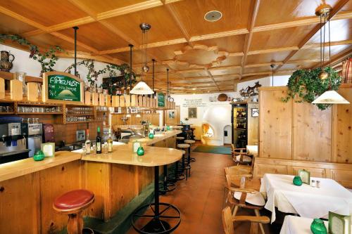 un restaurante con bar y algunas mesas y sillas en Hotel Grüner Baum, en Zell am See