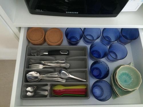 a drawer filled with blue cups and utensils at 3 bedrooms My resort huahin with free waterpark in Hua Hin