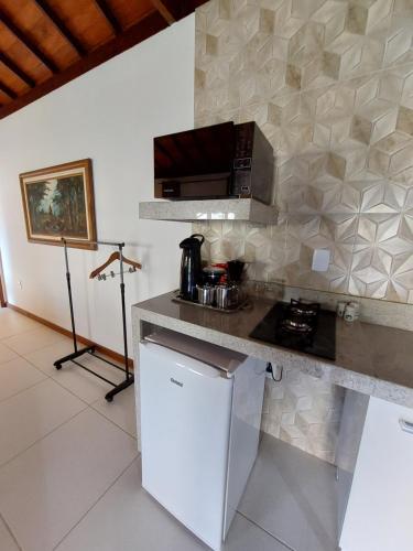 a kitchen with a counter top with a microwave at Lumiar Eco Lodge - Chalé Pedra Riscada in Nova Friburgo