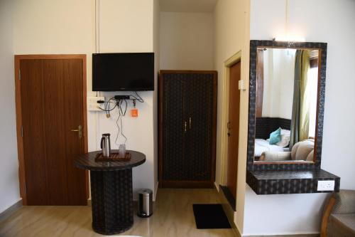 a room with a mirror and a room with a bed at PHIBHA VILLA in Shillong