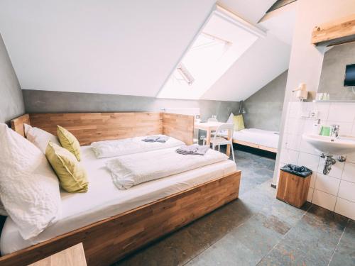 ein Schlafzimmer mit einem großen Bett und einem Waschbecken in der Unterkunft Gut Hügle Jugendzimmer in Ravensburg