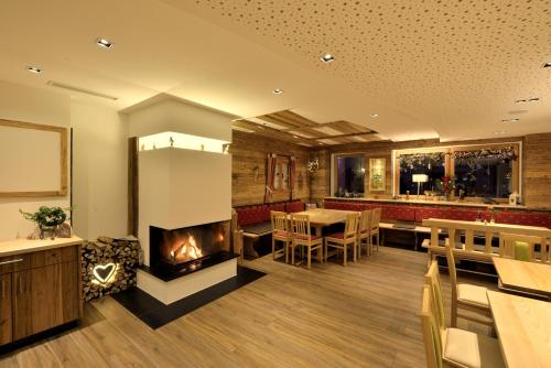 a living room with a fireplace and a dining room at Pension Waldkristall in Frauenau