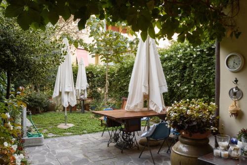 a table with white umbrellas in a garden at Appartamento Fanciullacci in Montelupo Fiorentino