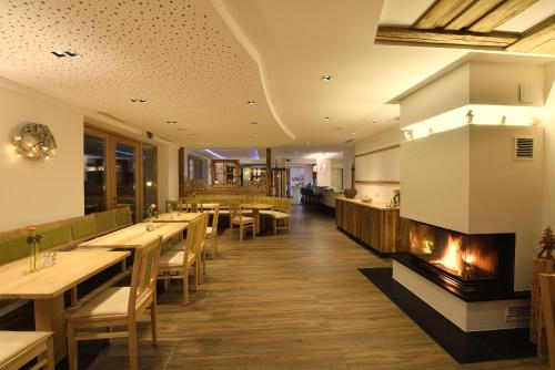 a restaurant with a fireplace and tables and chairs at Pension Waldkristall in Frauenau