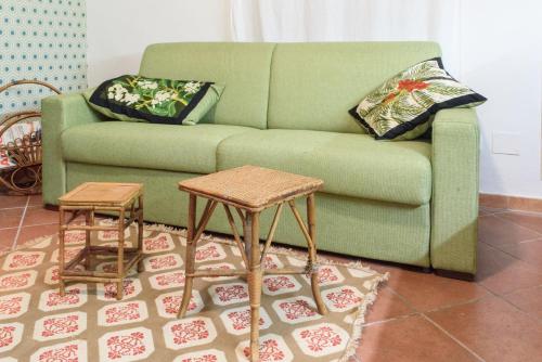 a green couch with two tables in a living room at Appartamento Fanciullacci in Montelupo Fiorentino