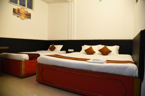 two beds in a hotel room withskirts at PHIBHA VILLA in Shillong
