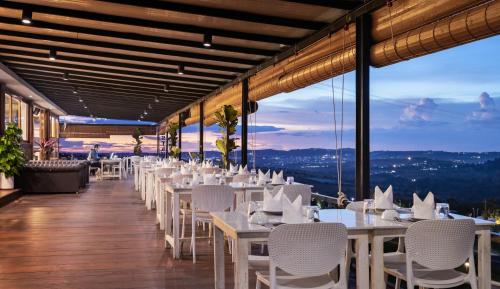 a restaurant with white tables and chairs and a view at Pidoma Resort in Sen Monorom