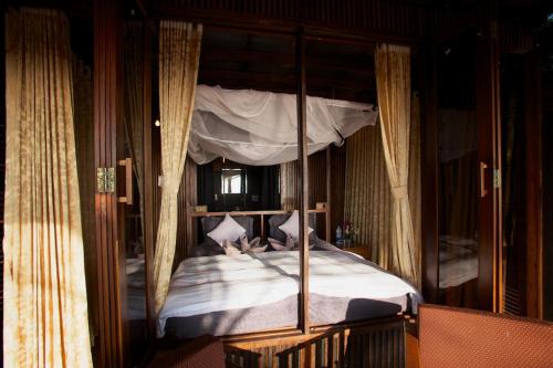 a bedroom with a canopy bed with white sheets at Dunhill Beach Resort in Agonda