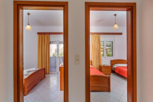 a view of a bedroom with a bed and a living room at Hara's Apartment 1 in Keratokampos