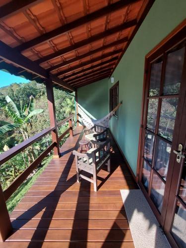 a balcony of a house with a swing at Lumiar Eco Lodge - Chalé Pedra Riscada in Nova Friburgo