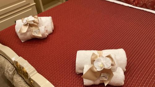 2 Handtücher mit Bogen auf dem Bett in der Unterkunft B&B Orchidea in Gioia Tauro
