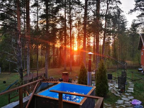 una mesa de ping pong en un patio trasero con el sol brillando entre los árboles en Large Family Apartment UNELMA - Tahko, Palju, BBQ, Sauna, WiFI, PetsOK, Budget, Wanha Koulu Tahkovuori, en Reittiö