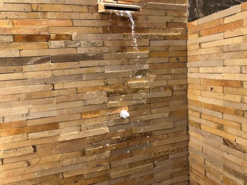 a shower in a brick wall with water coming out at Villa Viana in Jericoacoara