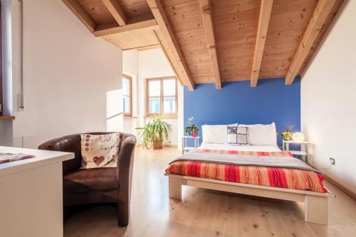 una camera con letto e sedia di Bbmarlene a Bolzano