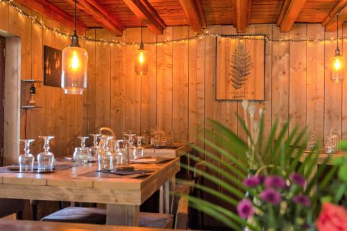 a restaurant with wooden walls and tables with glasses on them at Chalet Hôtel Les Blancs in Pra-Loup