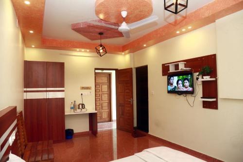 a living room with a tv on the wall at MIST RESIDENCY in Kattappana