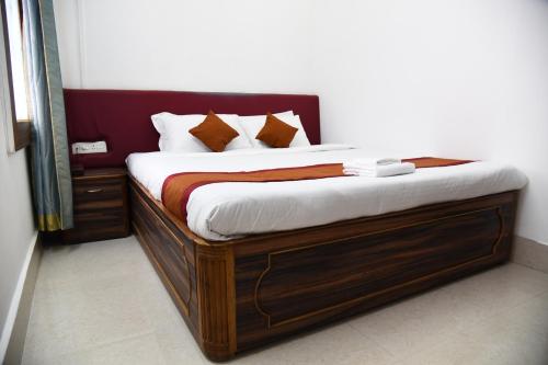 a bed with a wooden frame with pillows on it at PHIBHA VILLA in Shillong