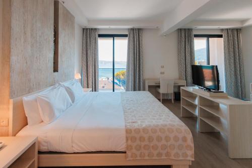 ein Hotelzimmer mit einem großen Bett und einem TV in der Unterkunft Palmon Bay Hotel & Spa in Herceg-Novi