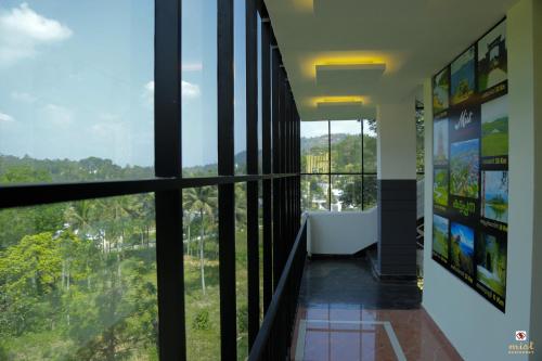 a hallway with large windows with a view of trees at MIST RESIDENCY in Kattappana