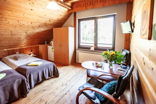 een slaapkamer met een bed en een tafel in een kamer bij Weekend house w lesie, na Kaszubach in Rybaki