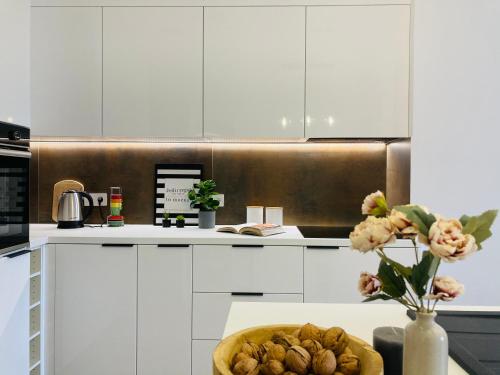 una cocina con armarios blancos y un tazón de comida en Apartament lovely space en Rzeszów