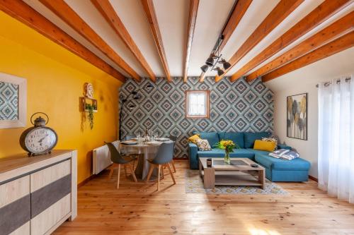 - un salon avec des murs jaunes et un canapé bleu dans l'établissement Dido Newfy Home, à Sainte-Marie-au-Bosc