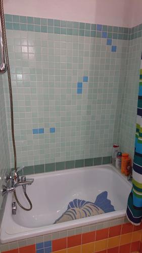 a bath tub in a bathroom with a tile wall at Casa Vacanza PIAZZA APARTMENT 1 in SantʼAndrea di Conza