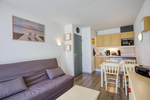 un salon avec un canapé et une cuisine dans l'établissement Le Val 1800 - Appartement avec Terrasse, à Valmeinier