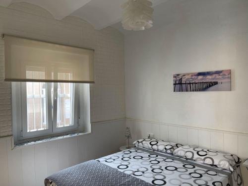 een slaapkamer met een bed en een raam bij Lleida 25, casa de poble a planta baixa amb àmplia terrassa equipada in Sant Carles de la Ràpita