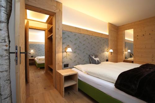 サン・ヴィジリオ・ディ・マレッベにあるResidence Garni Stellaの大きなベッドと木製の壁が備わるベッドルーム1室が備わります。